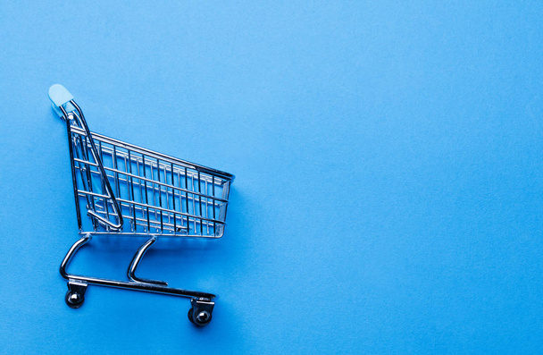 Shopping cart on a blue background - Фото, зображення