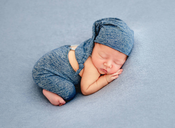 Cute boy in blue bonnet sleeping - 写真・画像