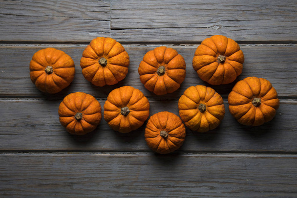 MIni pumpkins arranged on a rustic wooden background - Foto, imagen