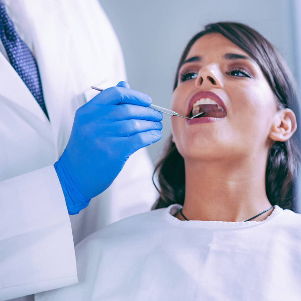 Jonge vrouw met een tandheelkundige Check-up - Foto, afbeelding