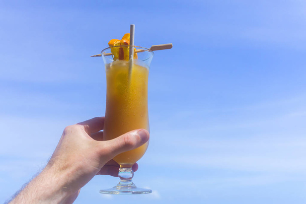 Tropical cocktail with orange against blue sky - Fotó, kép