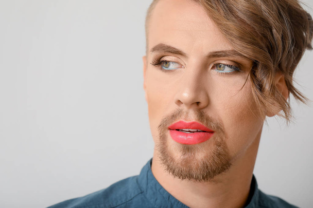 Портрет молодой трансгендерной женщины на светлом фоне
 - Фото, изображение