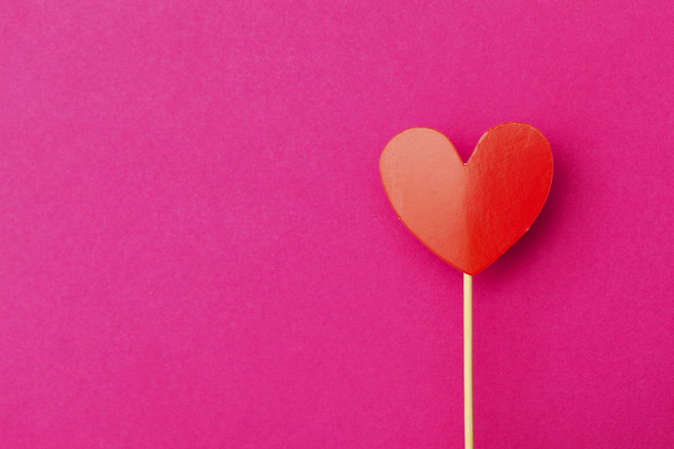 Paper heart on a stick over a bright pink background - Fotoğraf, Görsel