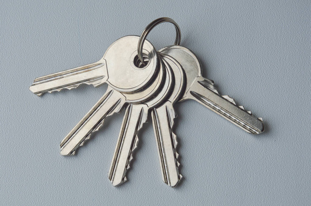 a bunch of keys on a gray background. metal keys. door key. - Foto, imagen