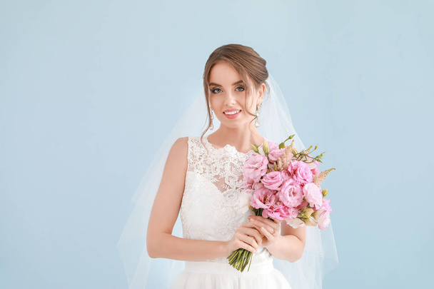 Retrato de hermosa novia joven con ramo de boda sobre fondo claro
 - Foto, imagen