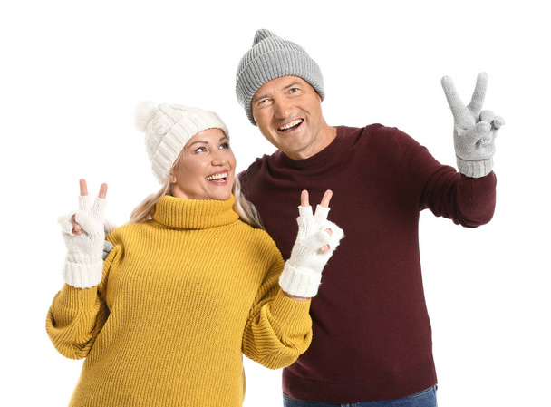 Portrait of happy mature couple showing victory gesture on white background - Photo, image