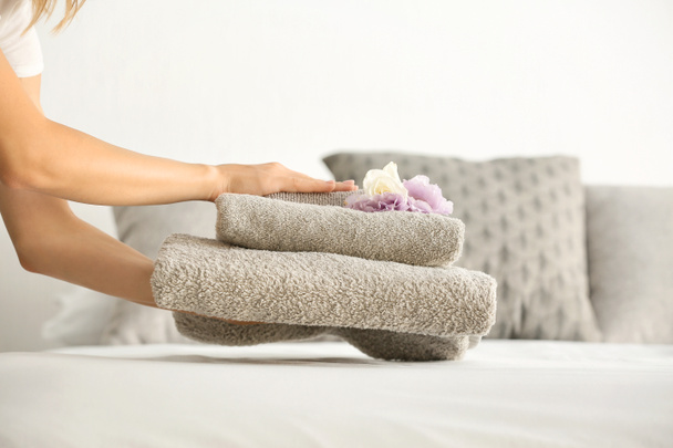 Kobieta oddanie czyste ręczniki na łóżku - Zdjęcie, obraz