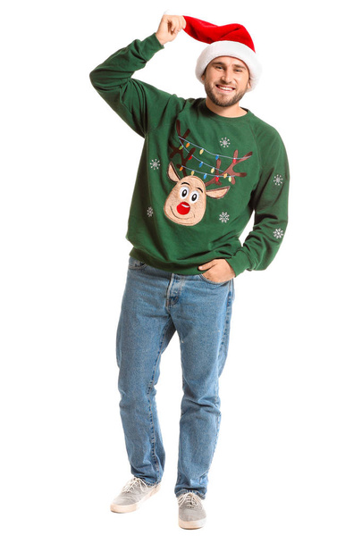 Fiatal férfi karácsonyi pulóver és Mikulás kalap fehér háttér - Fotó, kép
