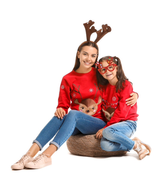 Engraçado jovem mulher e sua filha em camisolas de Natal no fundo branco
 - Foto, Imagem