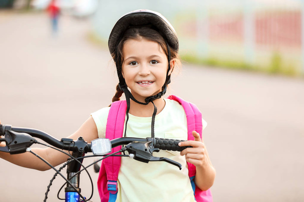 Cute girl riding bicycle outdoors - Photo, image