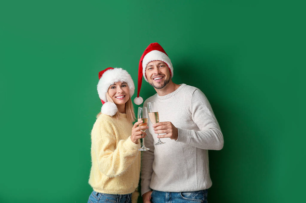 Boldog pár Santa kalap ivás pezsgő a színes háttér - Fotó, kép
