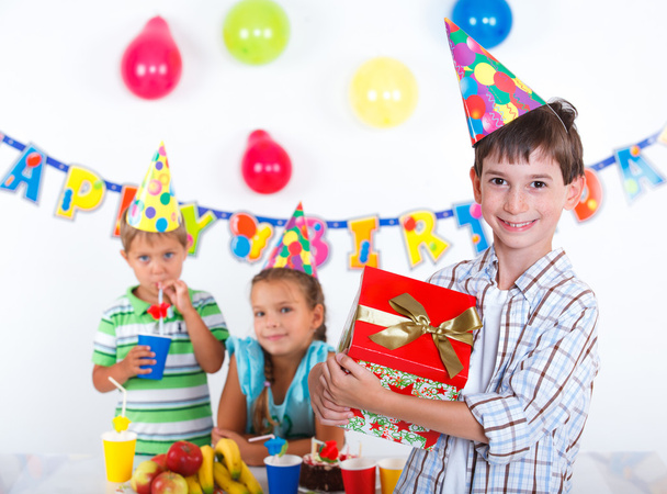 Мальчик с подарочной коробкой на дне рождения
 - Фото, изображение