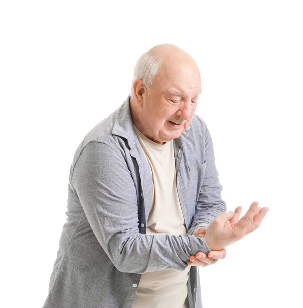 Ηλικιωμένος άνδρας που υποφέρει από πόνο στον καρπό σε λευκό φόντο - Φωτογραφία, εικόνα