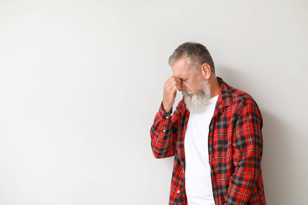 Idősebb férfi szenved fejfájás fény háttér - Fotó, kép