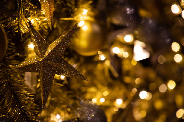 Nahaufnahme von goldener Weihnachtsdekoration mit Funkeln und Lichtern - Foto, Bild