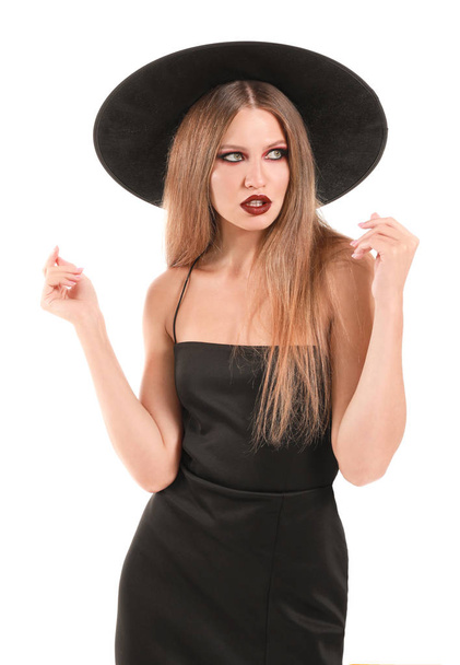 Mulher bonita vestida como bruxa para o Halloween no fundo branco - Foto, Imagem