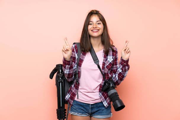 Jovem fotógrafa menina sobre isolado fundo rosa com dedos cruzando
 - Foto, Imagem