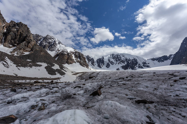 Landscape of snowy mountain pass on rocky ridge in sunny weather  - 写真・画像