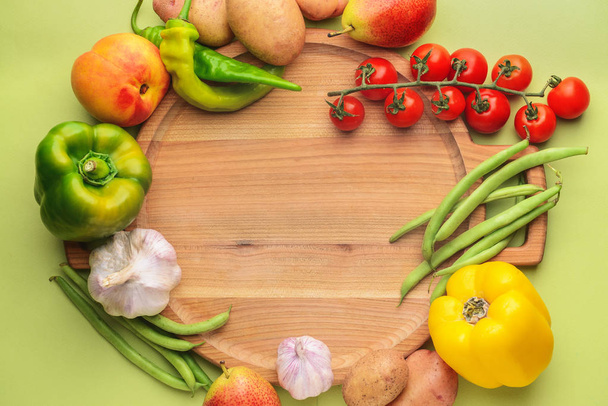 色の背景に多くの健康的な野菜や果物とボード - 写真・画像