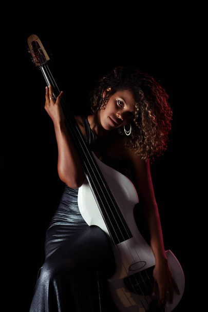 Sensual musician. African girl playing double bass. - Foto, immagini