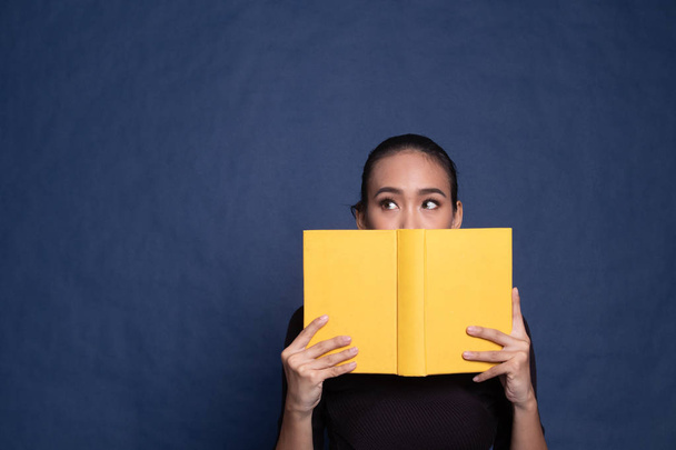 Young Asian woman with a book cover her face. - Φωτογραφία, εικόνα