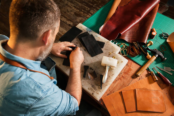 Man working with leather using crafting tools. - Foto, Imagem