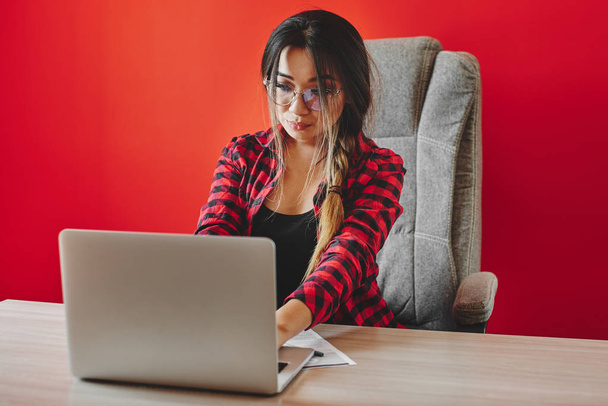 A young Kazakh woman startuper starts her own business from scratch. Asian girl businesswoman working on a laptop in an office. - Fotoğraf, Görsel