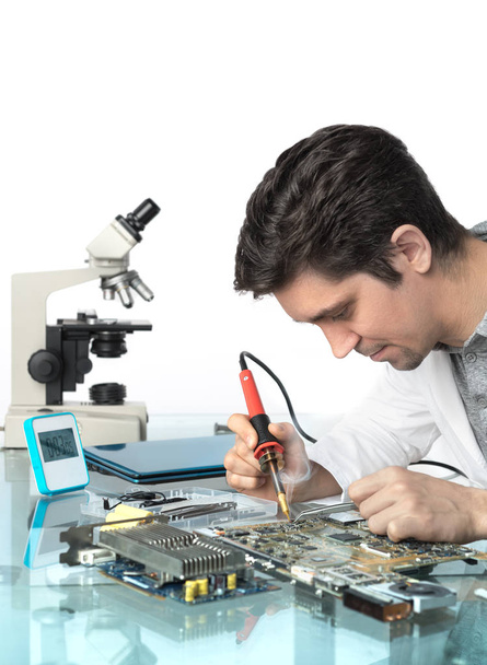 Young energetic male tech or engineer repairs electronic equipme - Φωτογραφία, εικόνα
