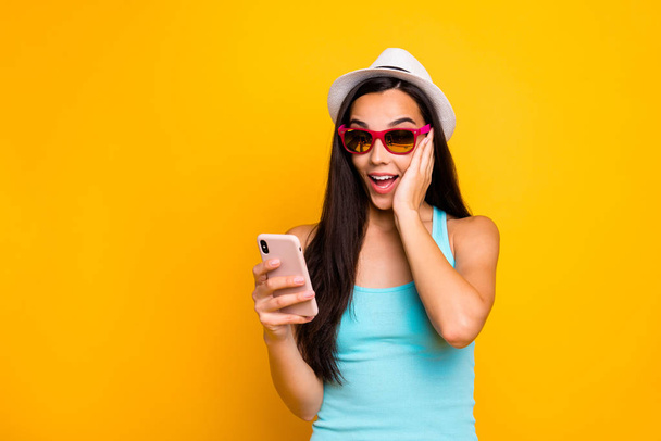 Photo of charming cute funny excited girl seeing new information on her phone held with her hands astonished of sales isolated with bright color background - Foto, Bild