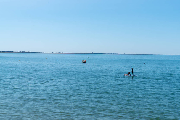 two girls on a paddle board at the edge of ile de Noirmoutier France - Photo, Image