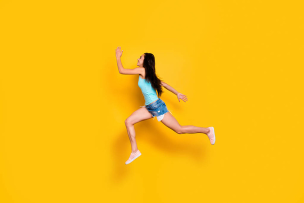 Full length body size photo of cheerful cute nice shopaholic hurrying up for shopping mall weaing jeans denim shorts turquoise tank-top isolated bright color background - 写真・画像