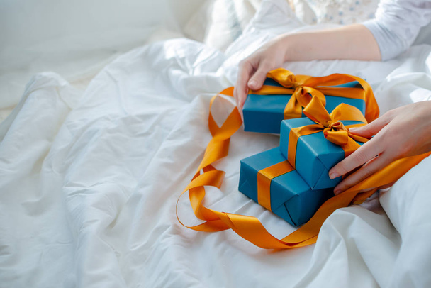 Naiskäsillä on sängyn vieressä lahjoja. Uusi vuosi ja joulu co
 - Valokuva, kuva