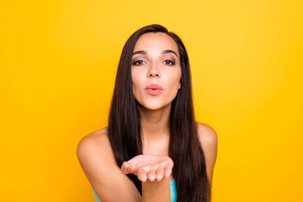Photo of charming brown haired attractive sincere kind friendly girlfriend sending you air kiss while isolated with vivid color background - Foto, Imagen