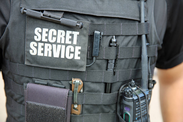 Az amerikai titkosszolgálat tisztje, különböző felszereléssel ellátott mellényt visel, a Fehér Ház előtt áll. Washingtonban. Egyesült Államok - Fotó, kép