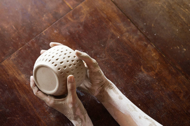 Female hands hold a wet clay bowl. Pottery making.  - Zdjęcie, obraz