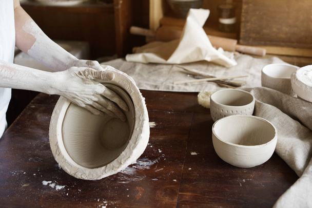 Female hands hold a bowl for casting clay products. Shaped method for making clay dishes. Handwork. Pottery making - Zdjęcie, obraz