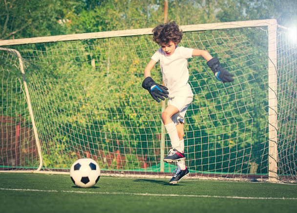 Summer soccer tournament for young kid. Football club. Emotions and joy of the game. Young goalie. Boy goalkeeper in football sportswear on stadium with ball. Sport concept. selective focus - Foto, immagini