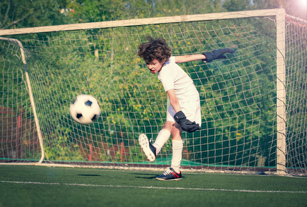 Summer soccer tournament for young kid. Football club. Emotions and joy of the game. Young goalie. Boy goalkeeper in football sportswear on stadium with ball. Sport concept. selective focus - Foto, Imagem