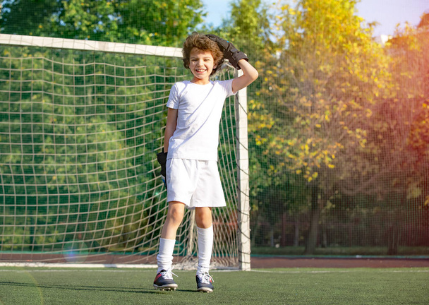 Summer soccer tournament for young kid. Emotions and joy of the game. Young goalie. Boy goalkeeper in football sportswear on stadium. Happy boy football player after goal scored - Photo, image