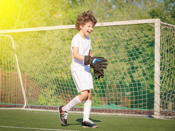 Summer soccer tournament for young kids. emotions and joy of the game. Young goalie. Boy goalkeeper in football sportswear on stadium. Happy boy football player after goal scored - Foto, imagen