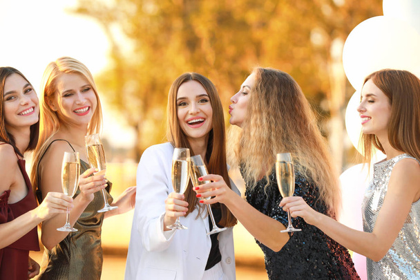 Piękne młode kobiety pijące szampana na wieczorze panieńskim na świeżym powietrzu - Zdjęcie, obraz
