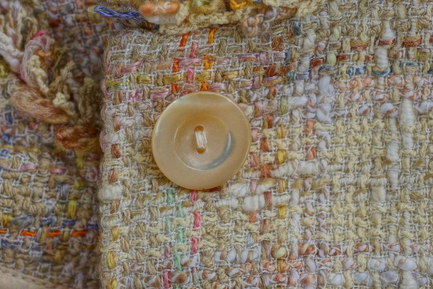 part of clothing made of woolen fabric and one brown button - Photo, Image