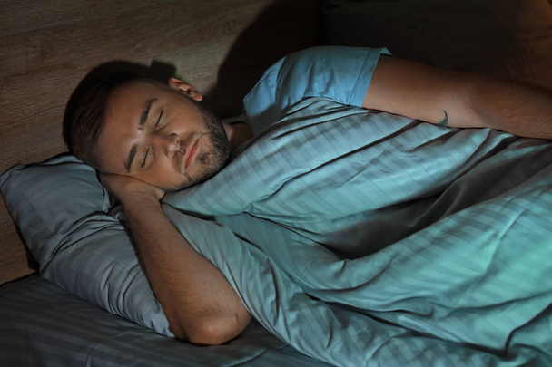 junger Mann schläft nachts im Bett - Foto, Bild