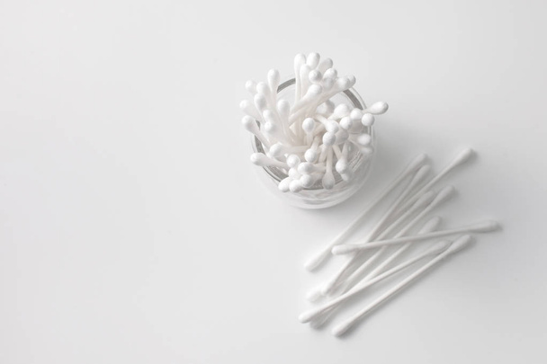 Cotton buds in a jar and next to the gray background. Overhand - Foto, imagen