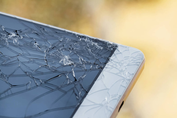 Rozbitá obrazovka. Poškozené sklo na smartphone. Detailní záběr, žluté pozadí, selektivní zaměření - Fotografie, Obrázek