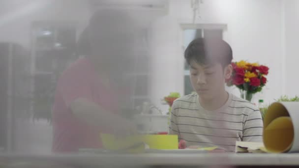 asiatische Mutter hilft meinem Sohn Kunst zu machen, um den Lehrer morgen zu schicken - Filmmaterial, Video