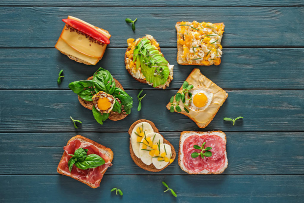 Différents sandwichs savoureux sur table en bois
 - Photo, image