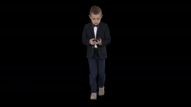 Kleine jongen in kostuum lopen en met behulp van smartphone, Alpha Channel - Video