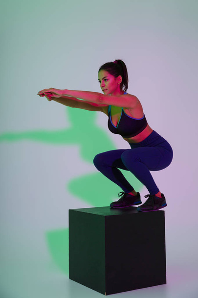 Serious sports woman make exercise isolated with led flash lights. - Foto, Imagen