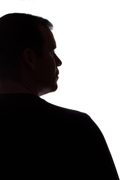 Portret van een jonge man, back View-donker geïsoleerd silhouet - Foto, afbeelding